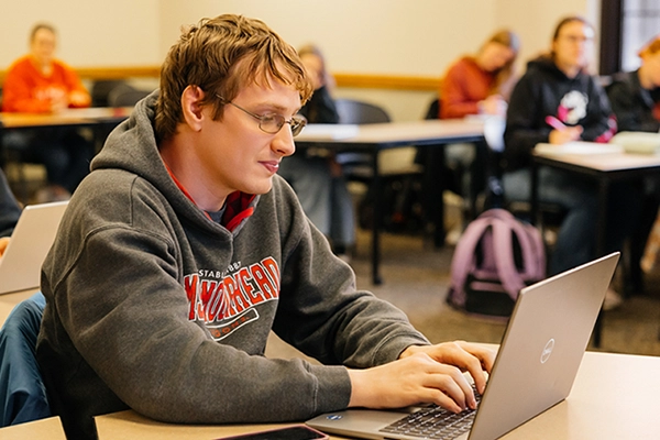 Student typing on laptop