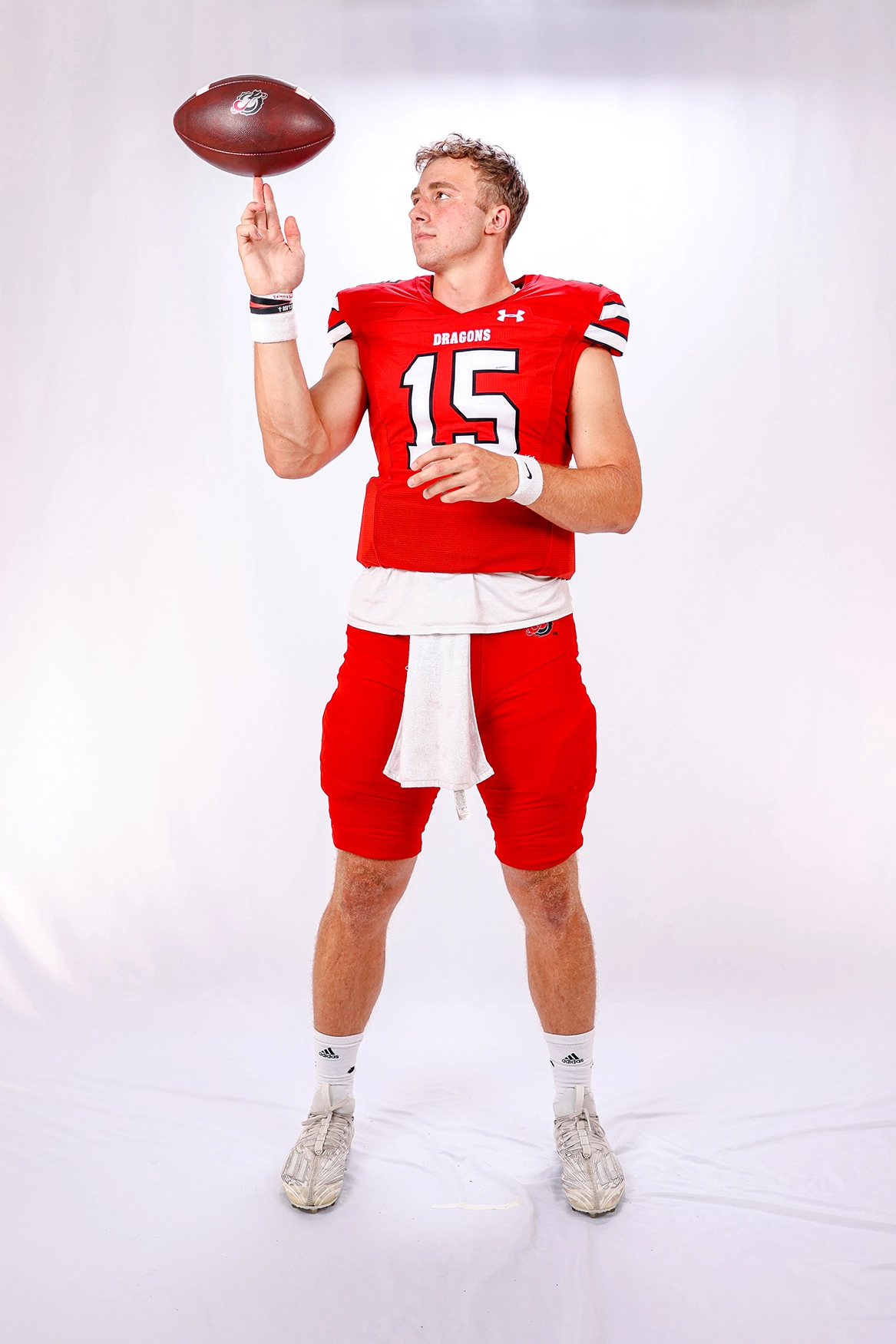 Jack Strand balances a football, posing in Dragon Football gear.