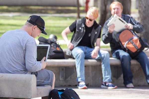 Students sitting on benches studying in the Sown area of the campus mall