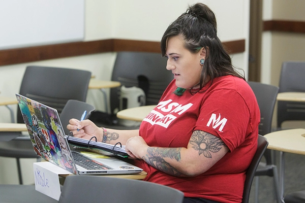 Student sitting at table with laptop