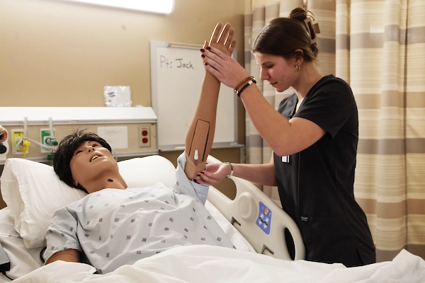 Nursing student examining patient